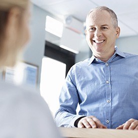 Smiling man checking in at front desk