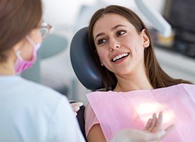 Woman in dental chair smiling at dentist