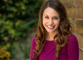 A woman smiling outside.