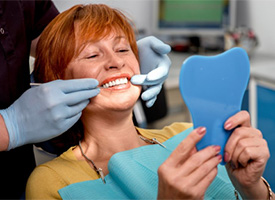 An older woman examining her smile.