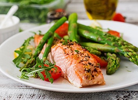 Plate filled with salmon and fresh vegetables