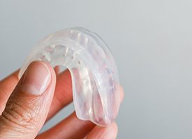 Closeup of patient holding clear mouthguard