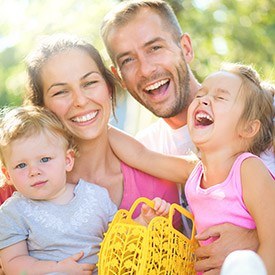 Mother father and two kids smiling outdoors