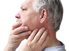 Man feeling jaw and neck before TMJ treatment in Acworth, GA