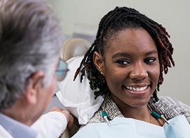 Woman smiling at dentist while sitting in dental chair