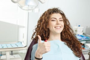 woman giving thumbs up while seeing holistic dentist 