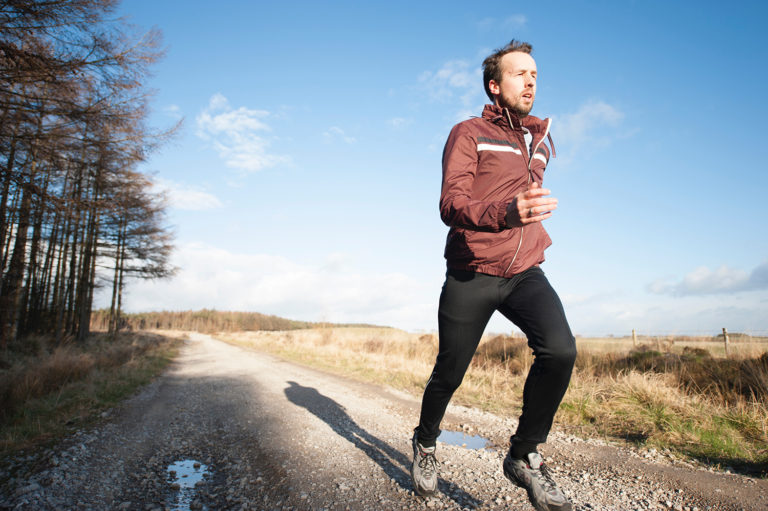 person jogging down dirt road